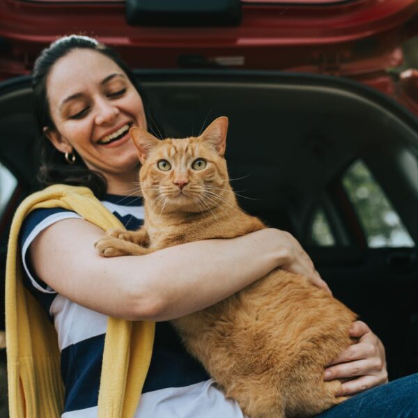 a women and her cat in the back seat of a car